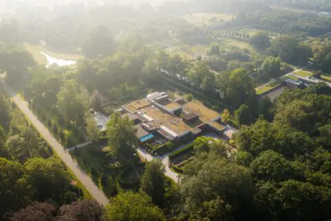 Luchtfoto van Crematorium Kranenburg en het omliggende bosrijke terrein.